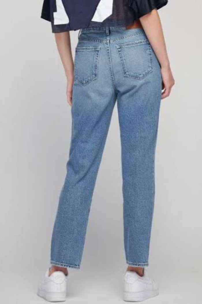 Person wearing light blue jeans on a plain background