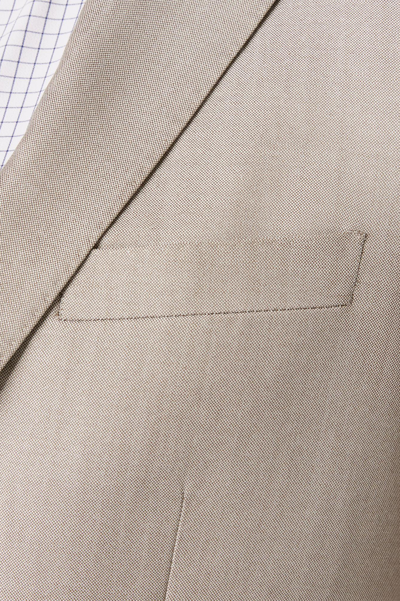 Close-up of a beige suit jacket with a pocket detail.