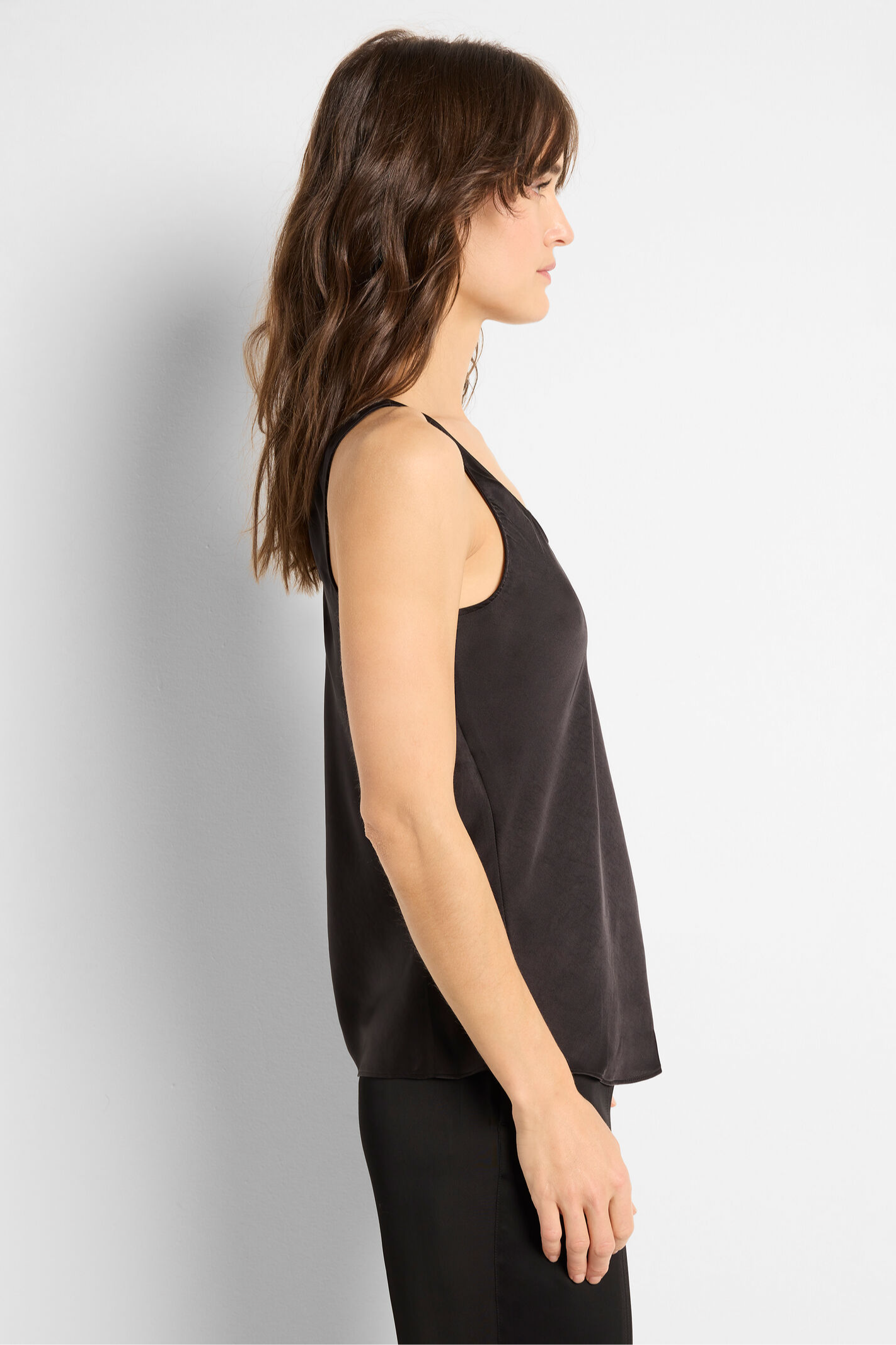 Woman wearing a black sleeveless top against a plain background