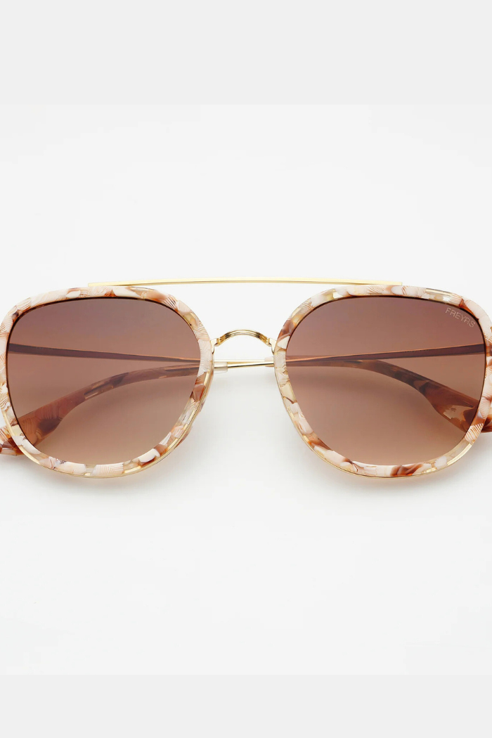 Sunglasses with gold frame and brown lenses on a white background