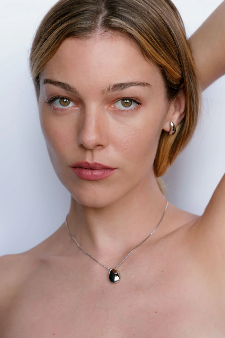 Woman wearing a necklace with a white background