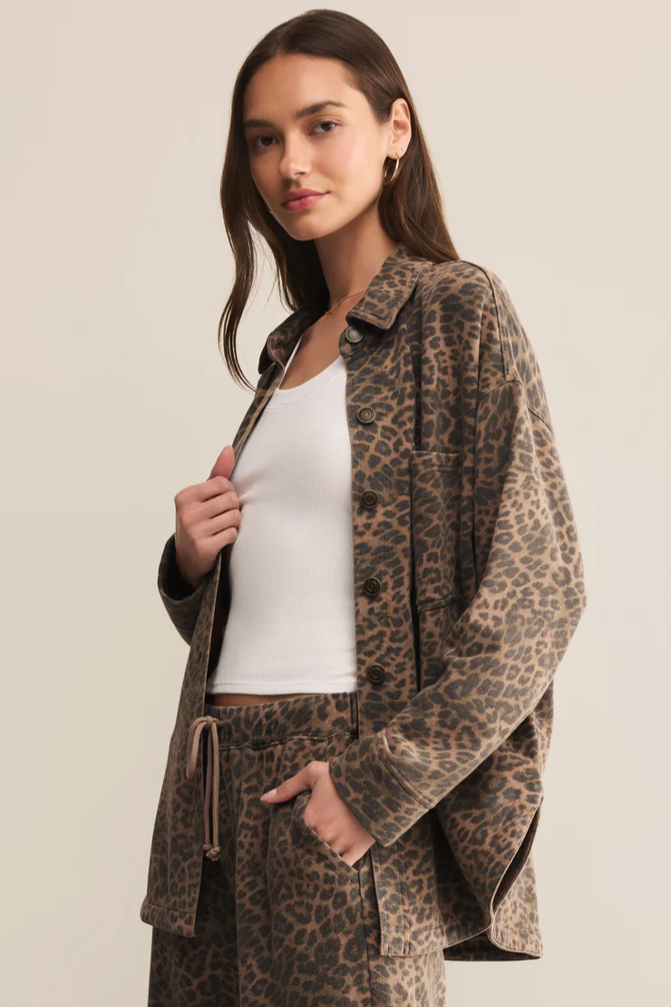 Woman wearing a leopard print coat and pants on a beige background