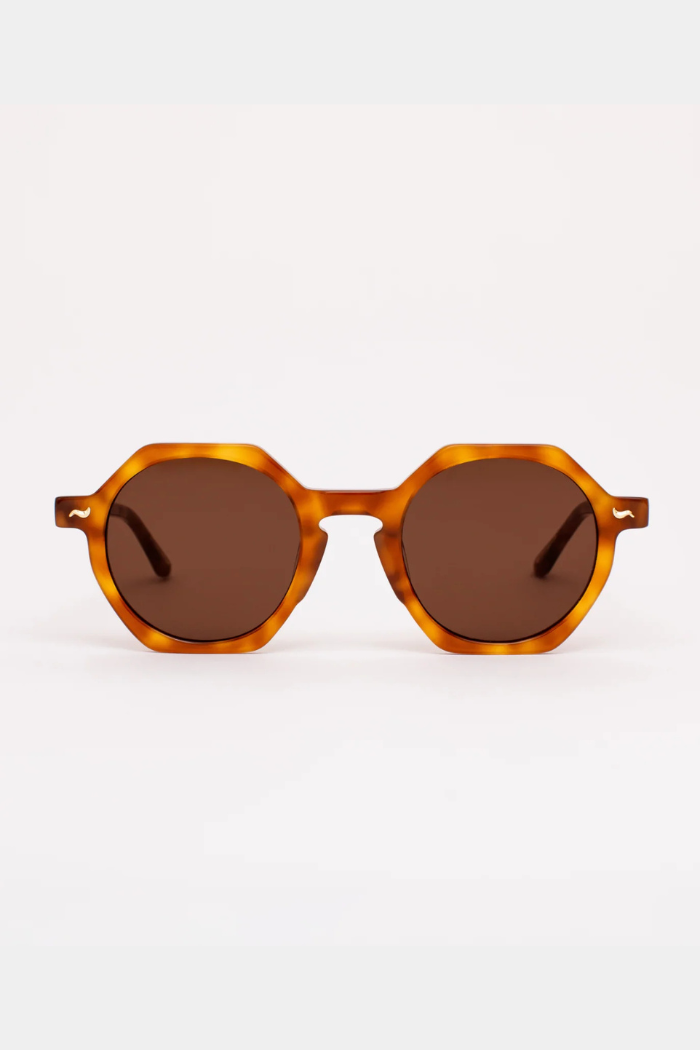 Sunglasses with tortoiseshell frame and brown lenses on a white background