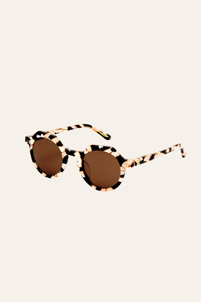 Round sunglasses with a leopard print frame on a beige background