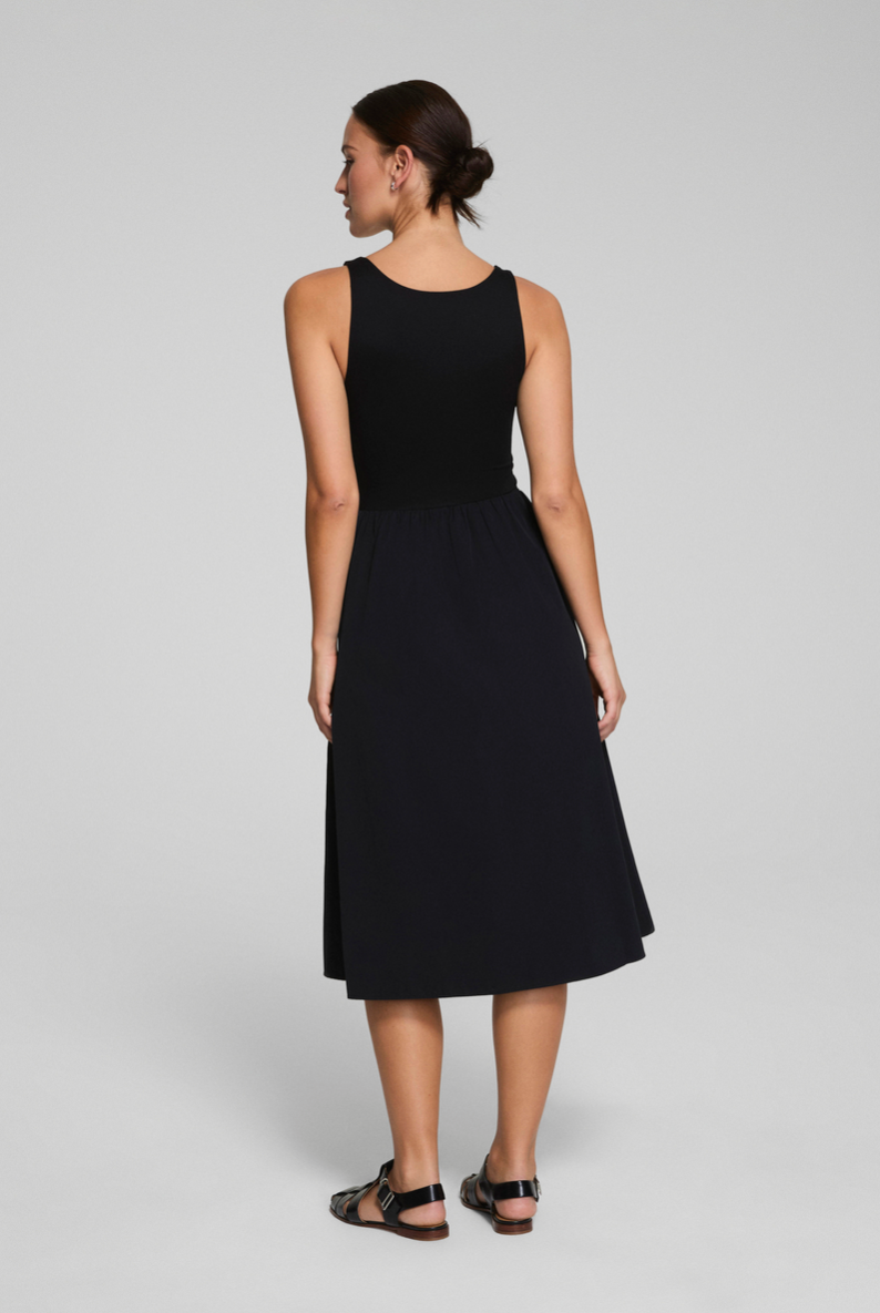 Woman wearing a black sleeveless dress on a gray background