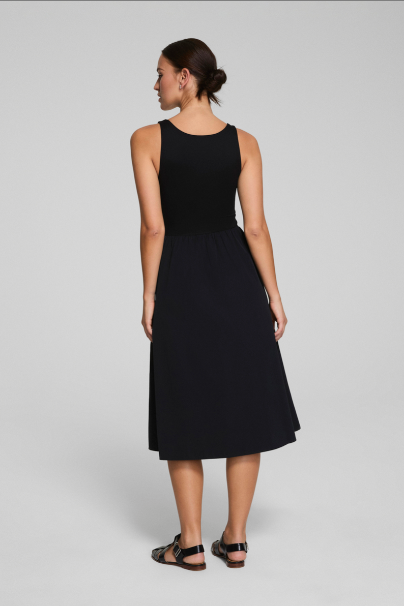 Woman wearing a black sleeveless dress on a gray background