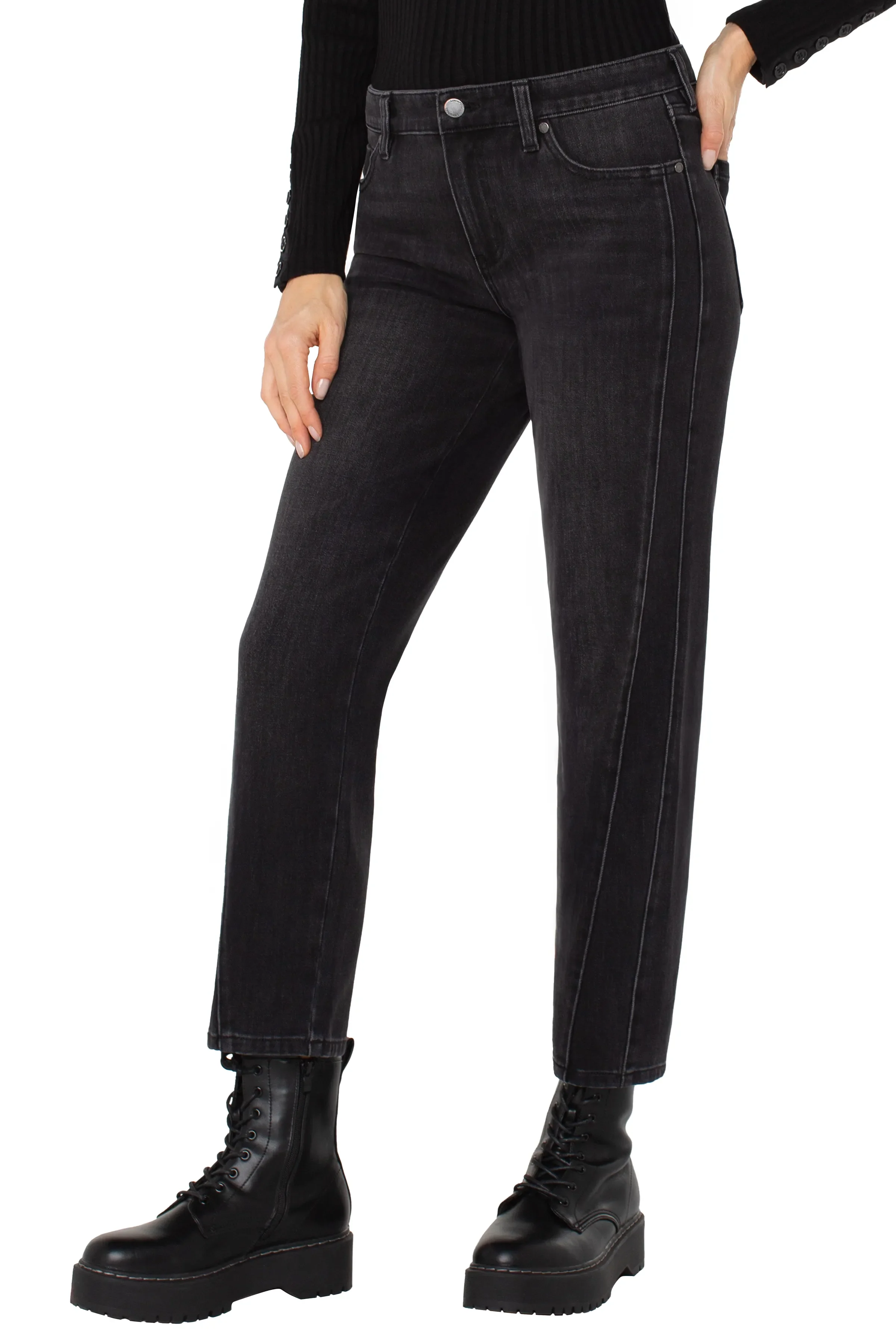 Person wearing black jeans and black boots on a white background