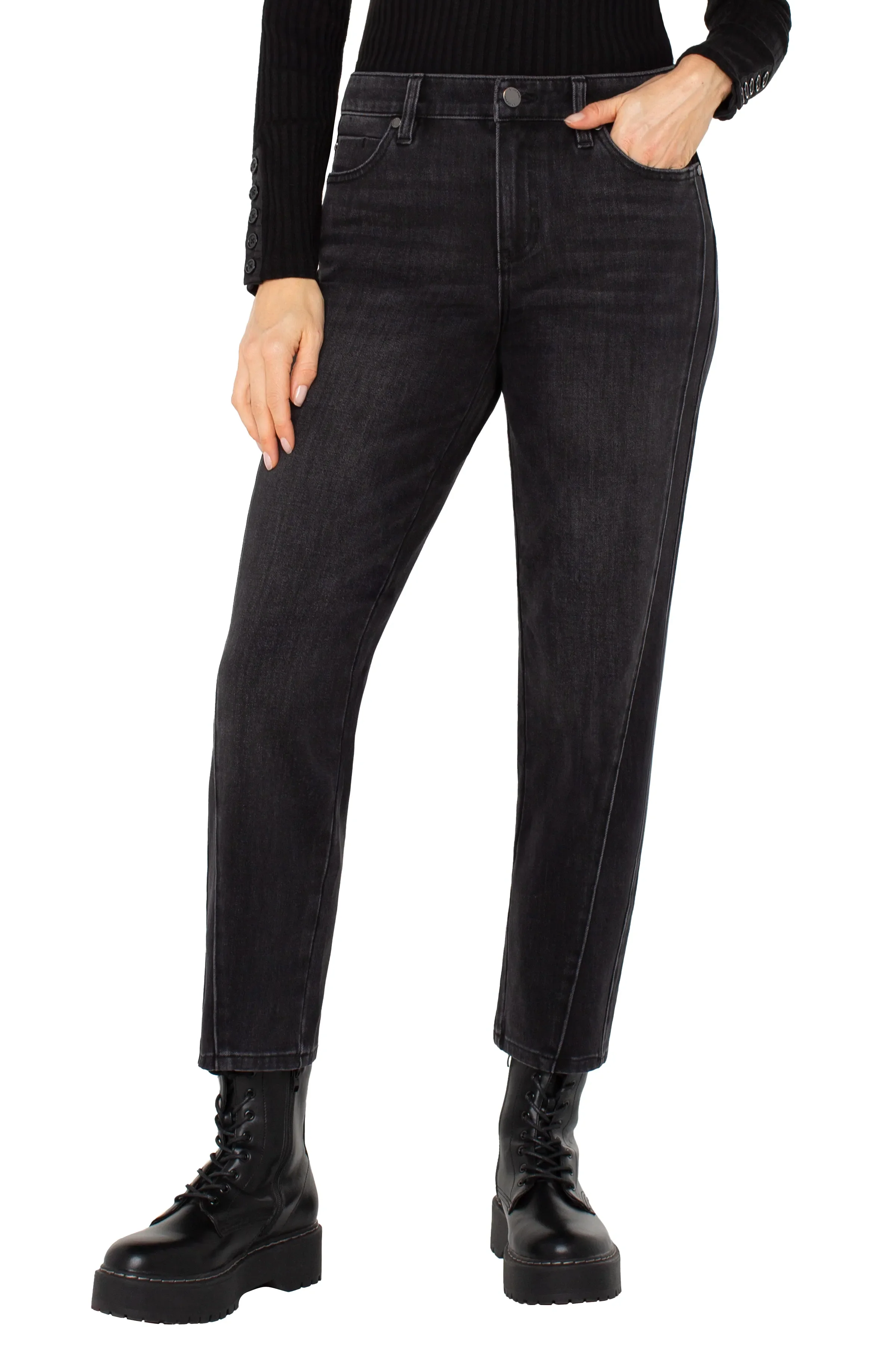 Person wearing black high-waisted jeans and black boots on a white background