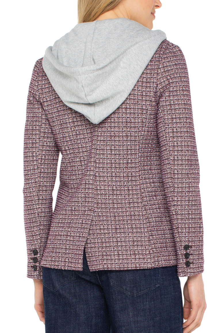 Person wearing a textured jacket with a hood on a white background