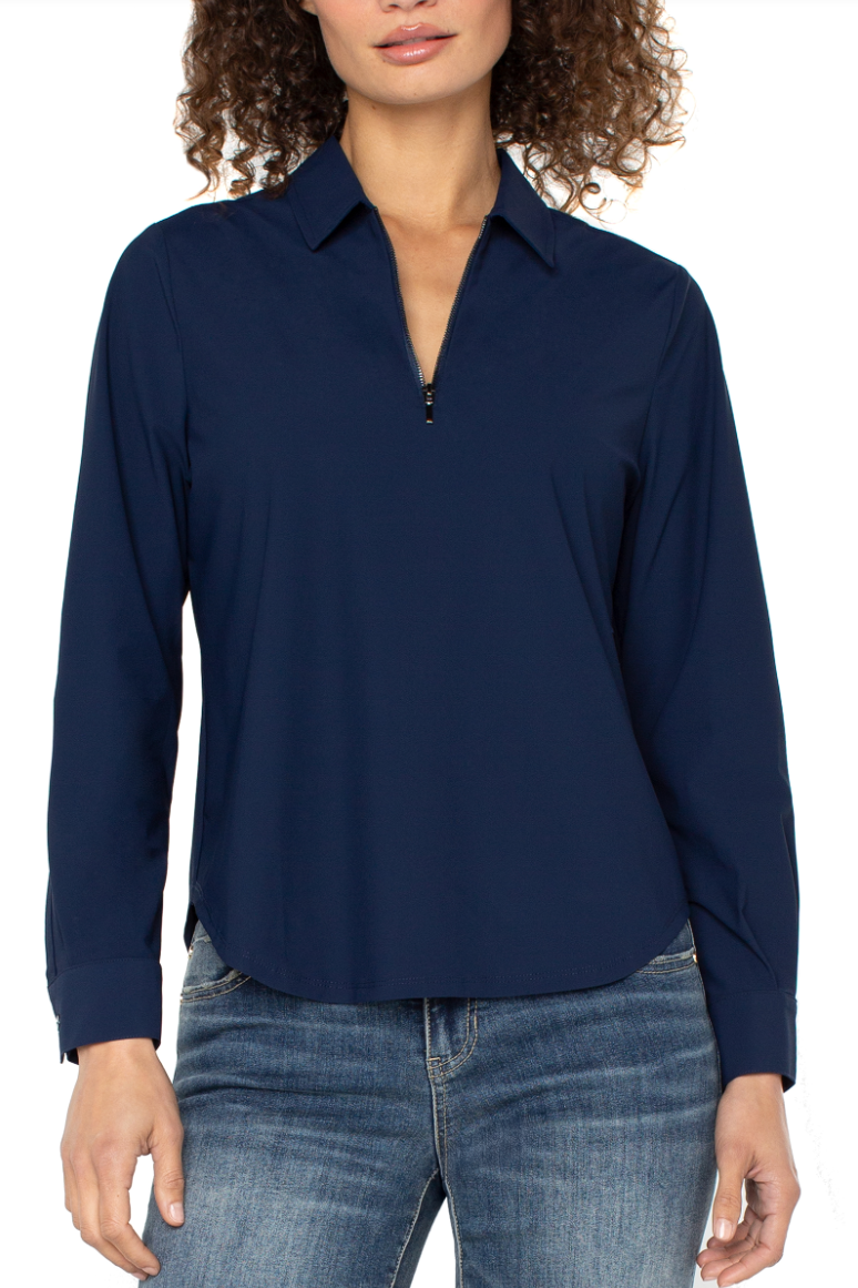 Woman wearing a navy blue long-sleeve shirt and jeans on a white background