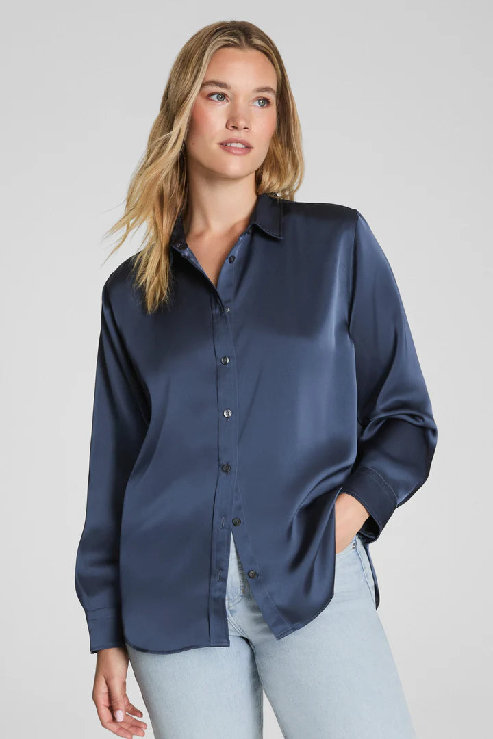 Woman wearing a navy blue shirt with a plain background