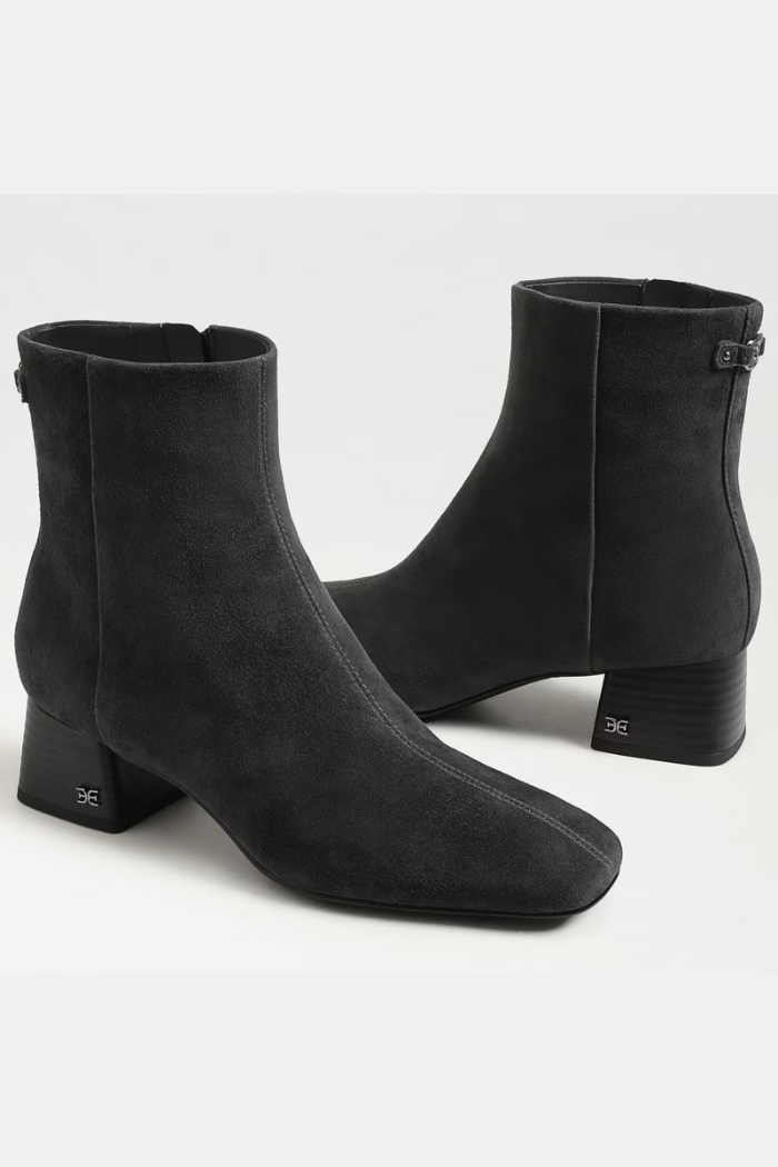 Pair of black ankle boots on a light gray background