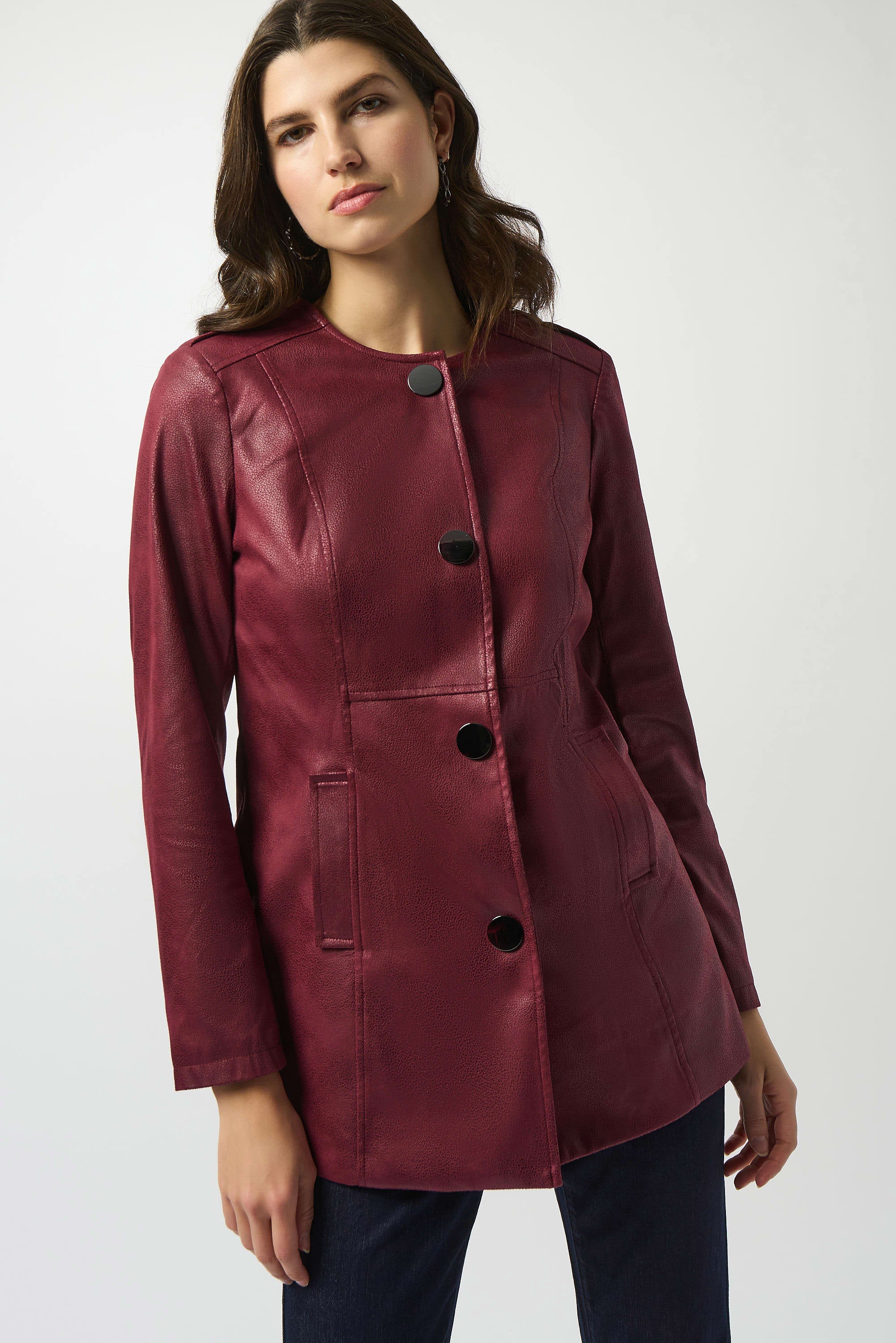 Woman wearing a burgundy leather jacket on a white background