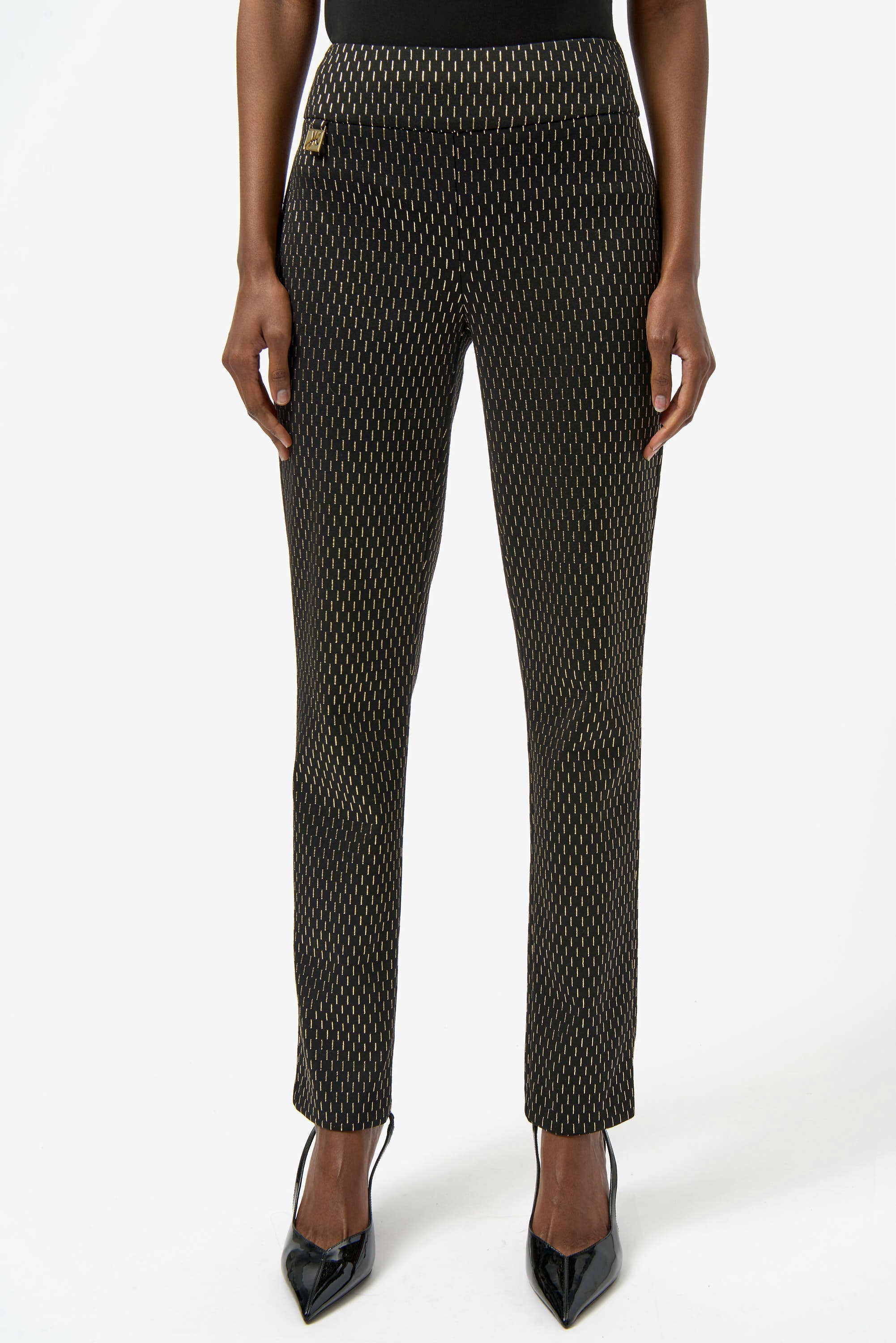 Black patterned pants worn by a person on a white background