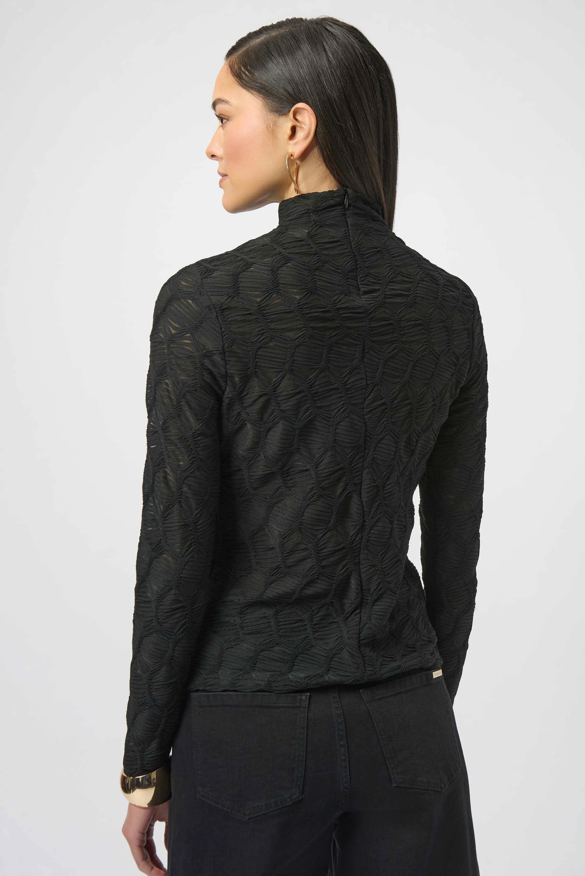 Person wearing a black textured jacket on a white background