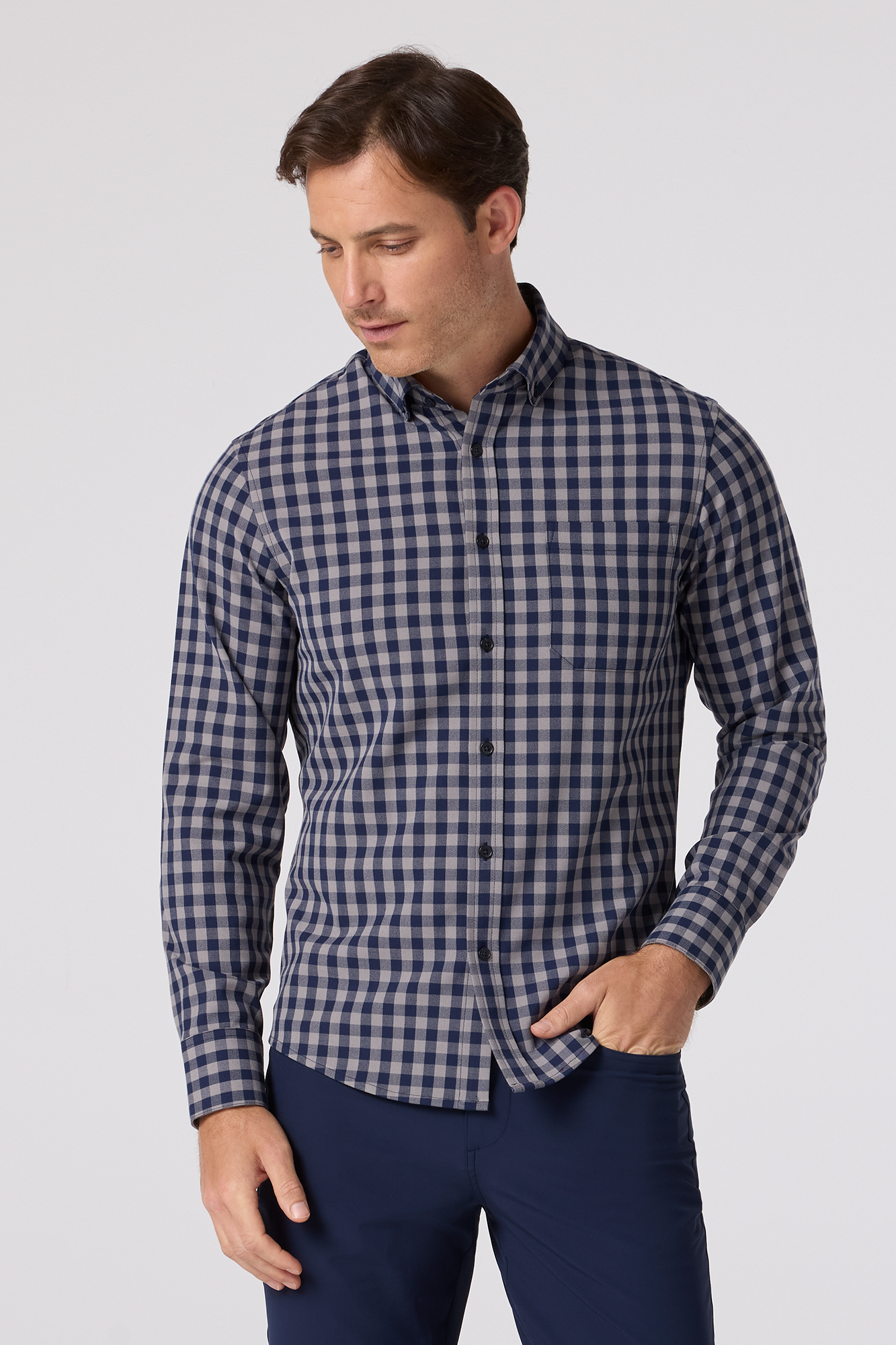 Man wearing a blue and white checkered shirt against a light gray background