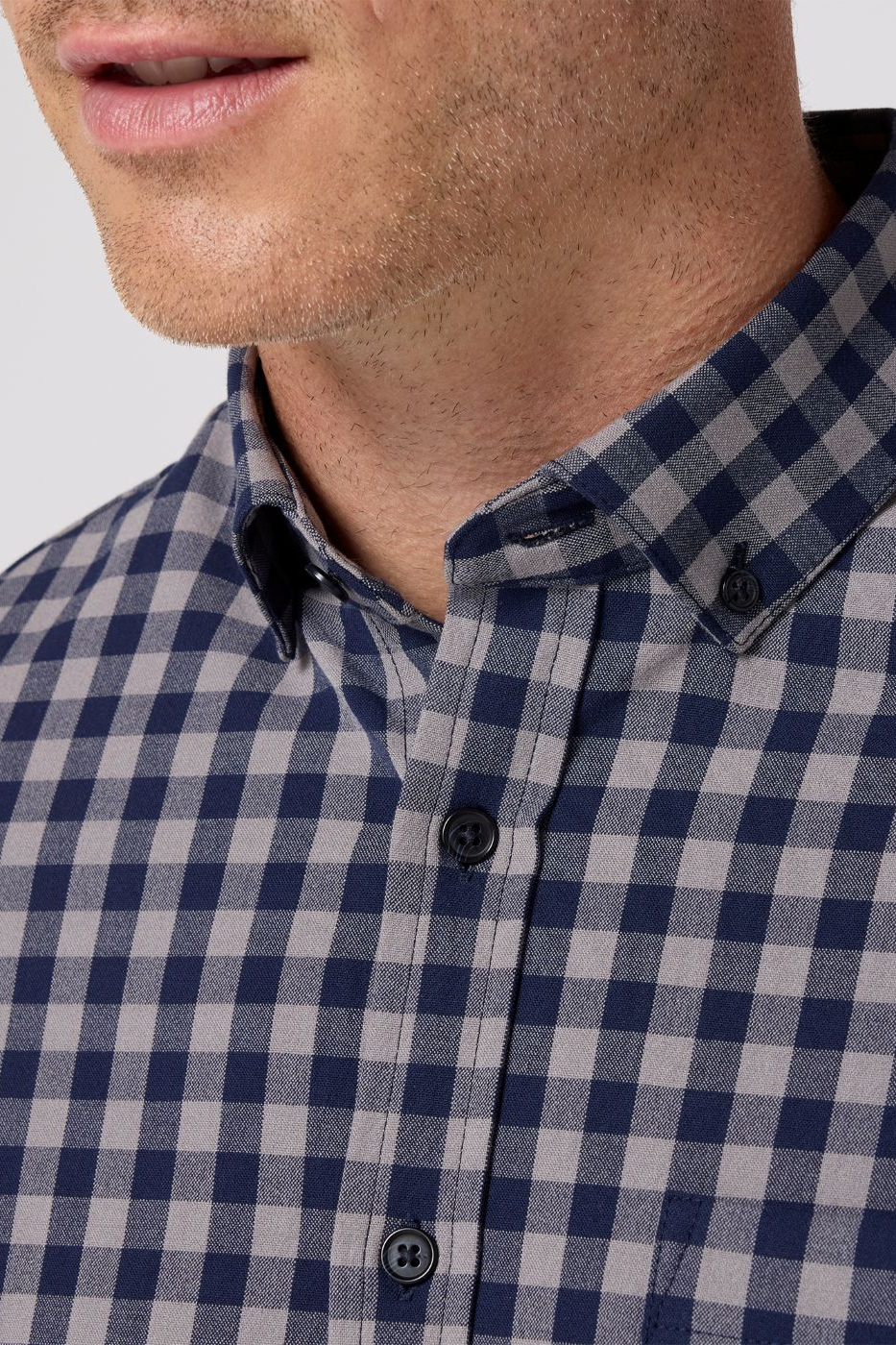 Close-up of a person wearing a blue and white checkered shirt.