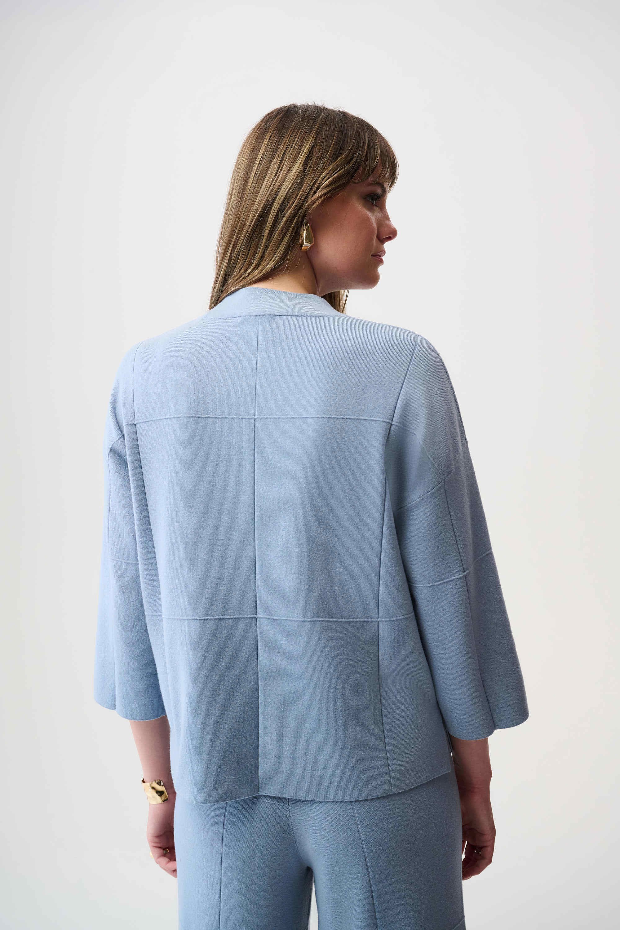 Woman wearing a light blue suit against a white background