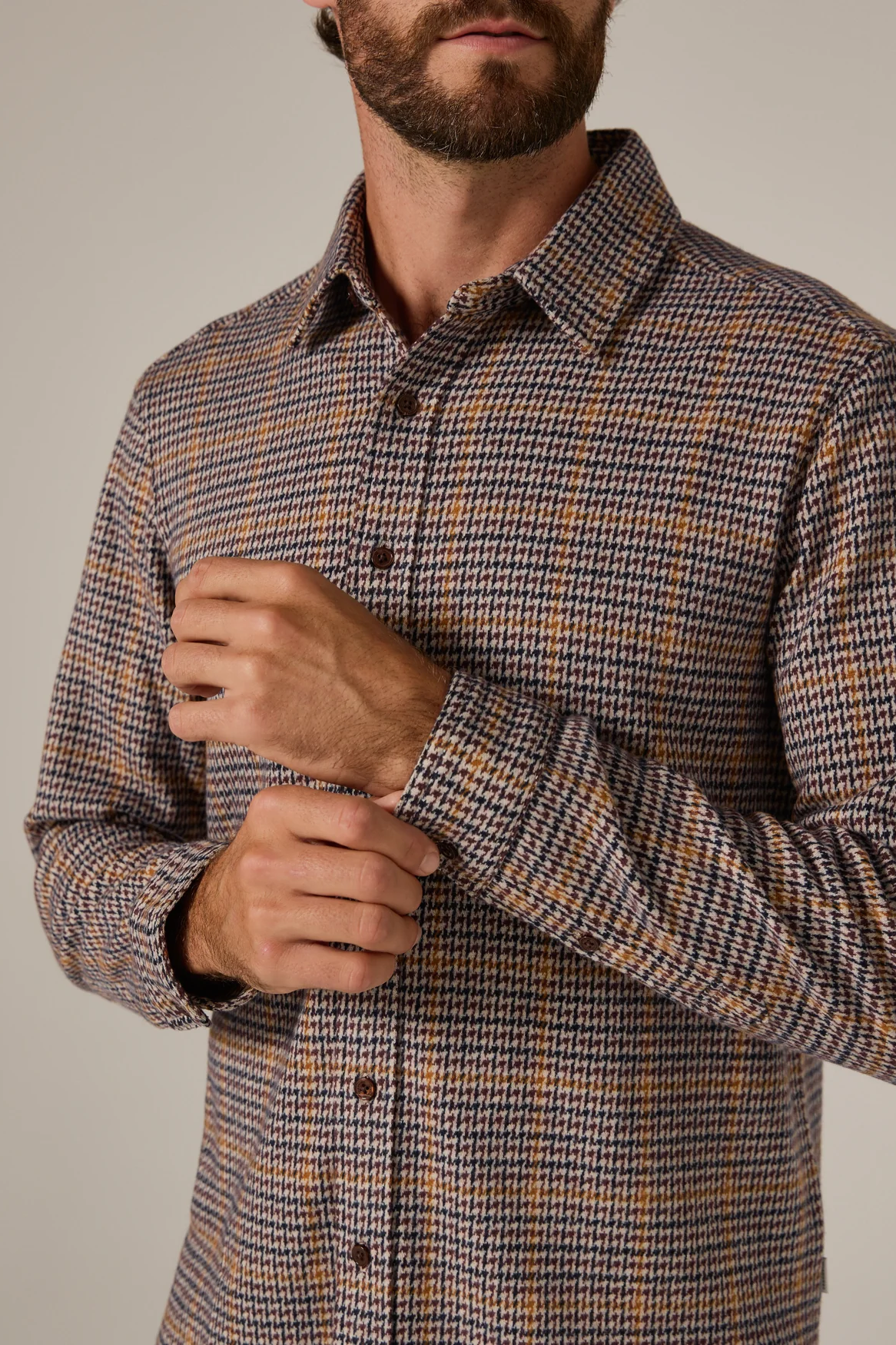 Man wearing a plaid shirt with a neutral background