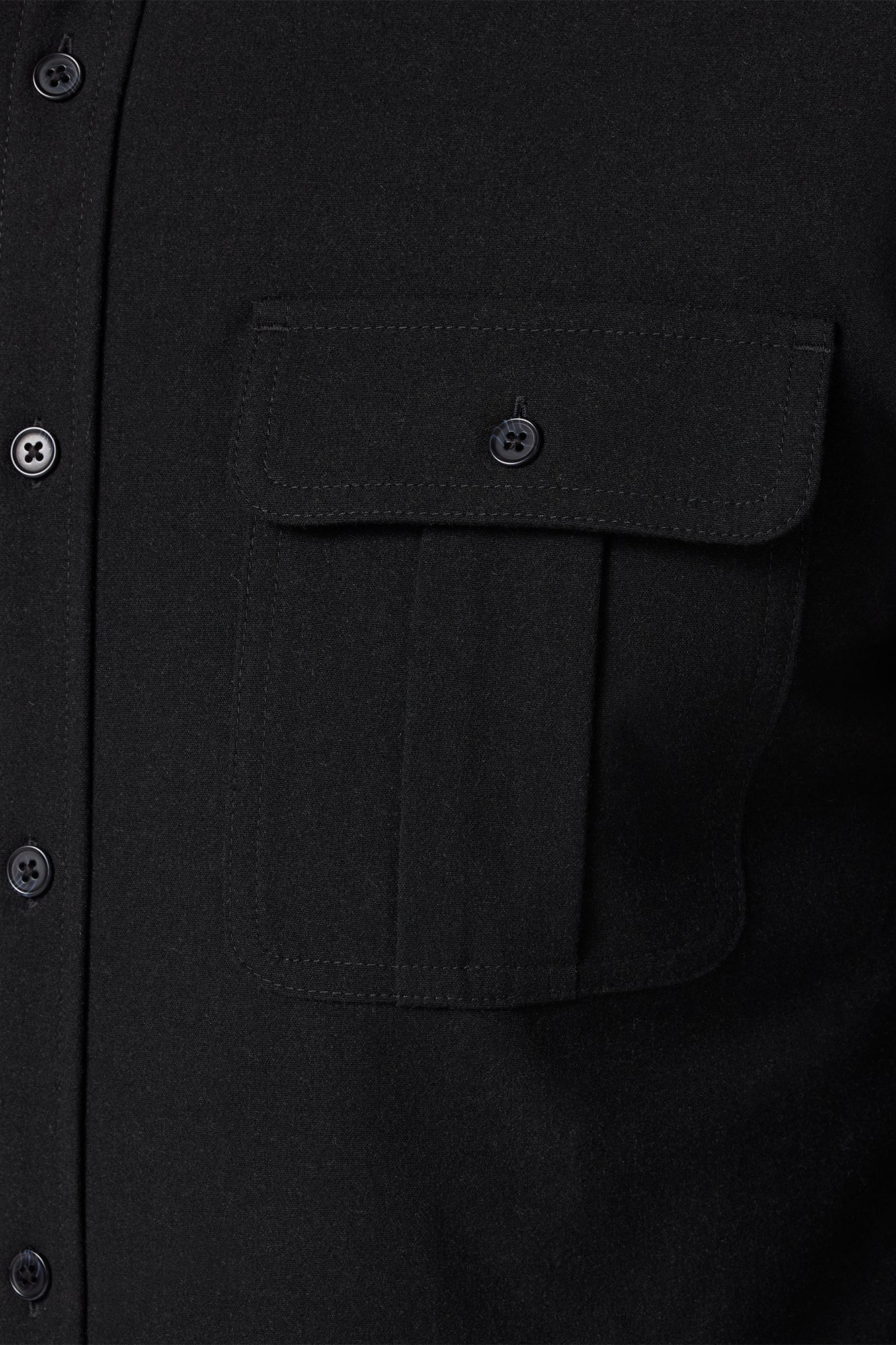 Close-up of a black shirt with a pocket and button details.
