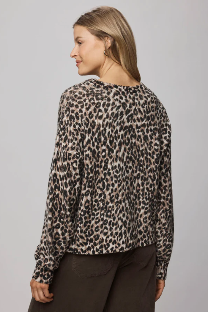 Woman wearing a leopard print top against a gray background