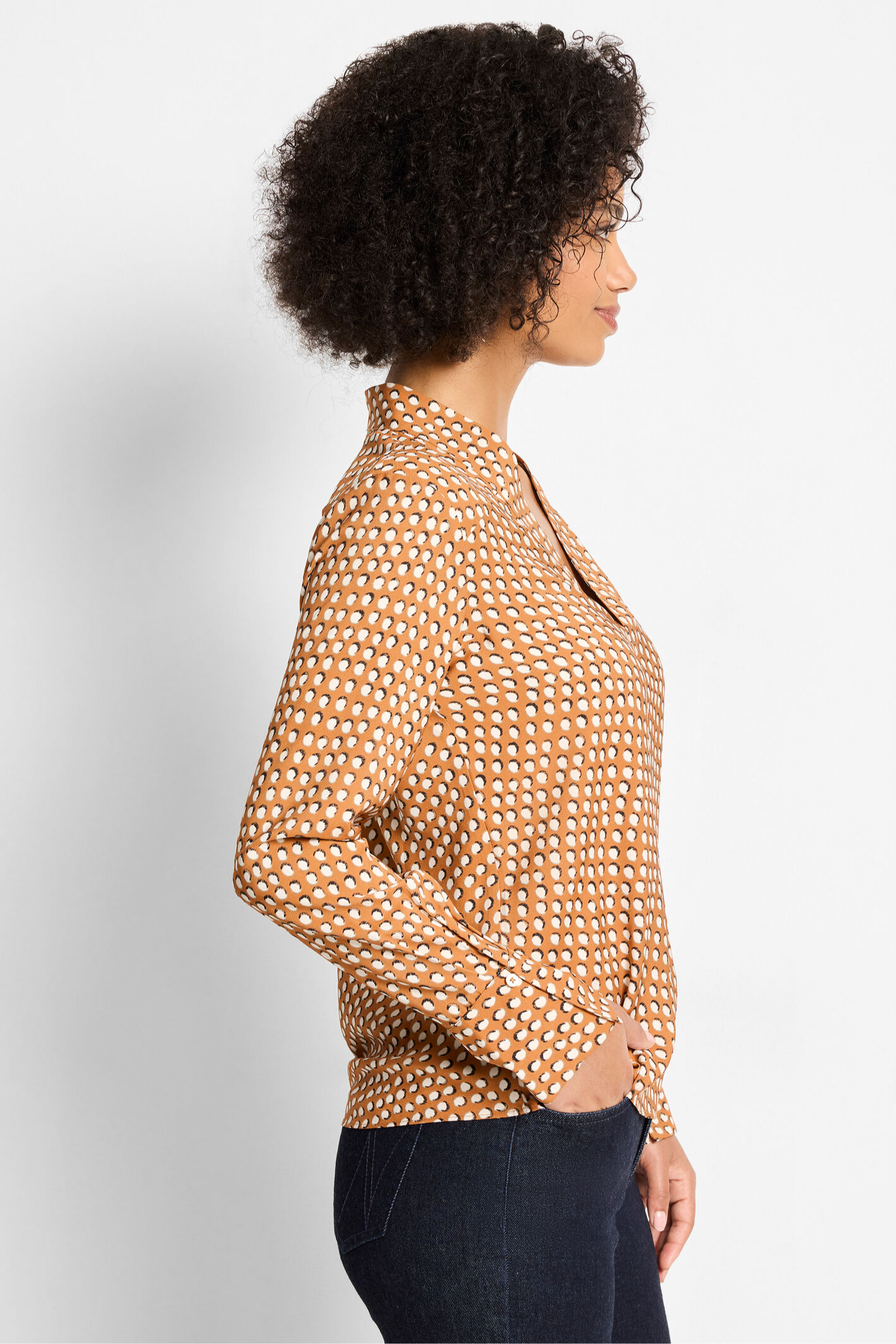 Woman wearing a patterned blouse against a plain background