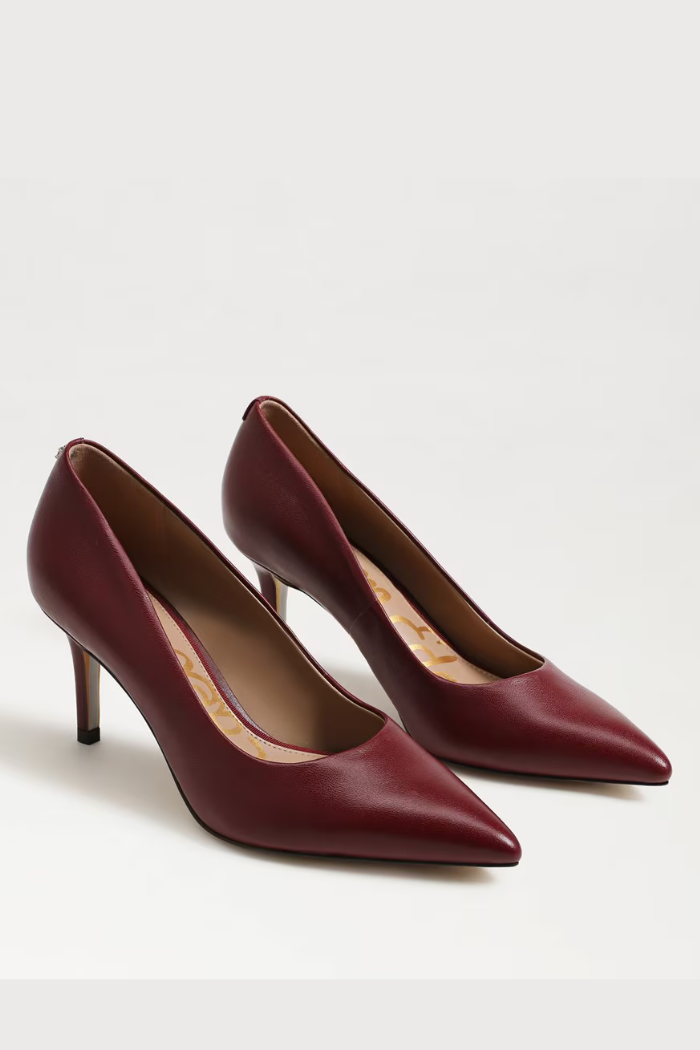 Pair of maroon high-heeled shoes on a light gray background