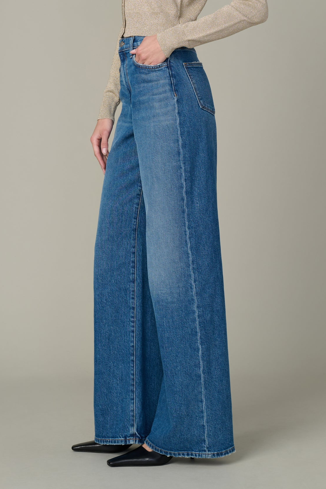Person wearing blue wide-leg jeans on a neutral background