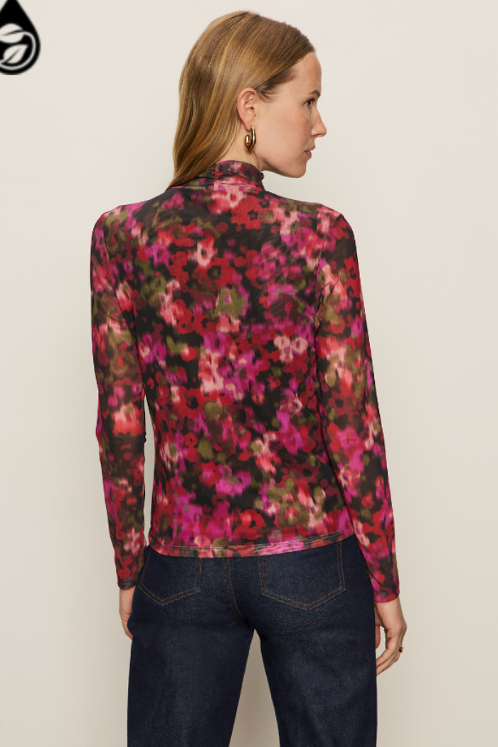 Woman wearing a floral long-sleeve top against a plain background