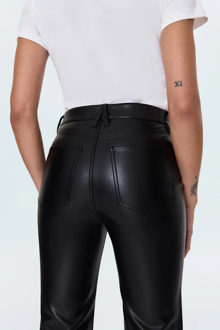 Person wearing black leather pants on a light blue background