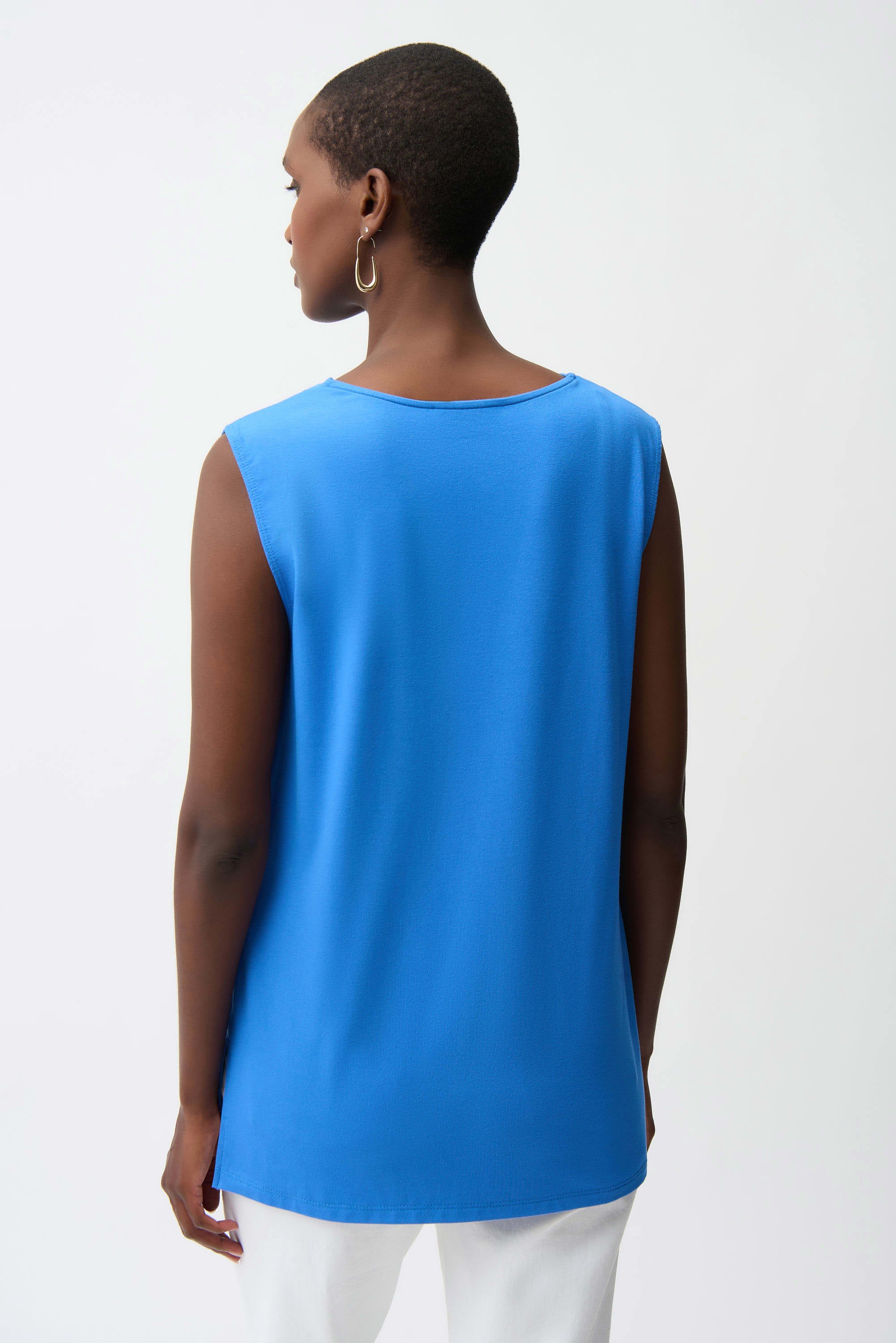 Person wearing a blue sleeveless top on a white background