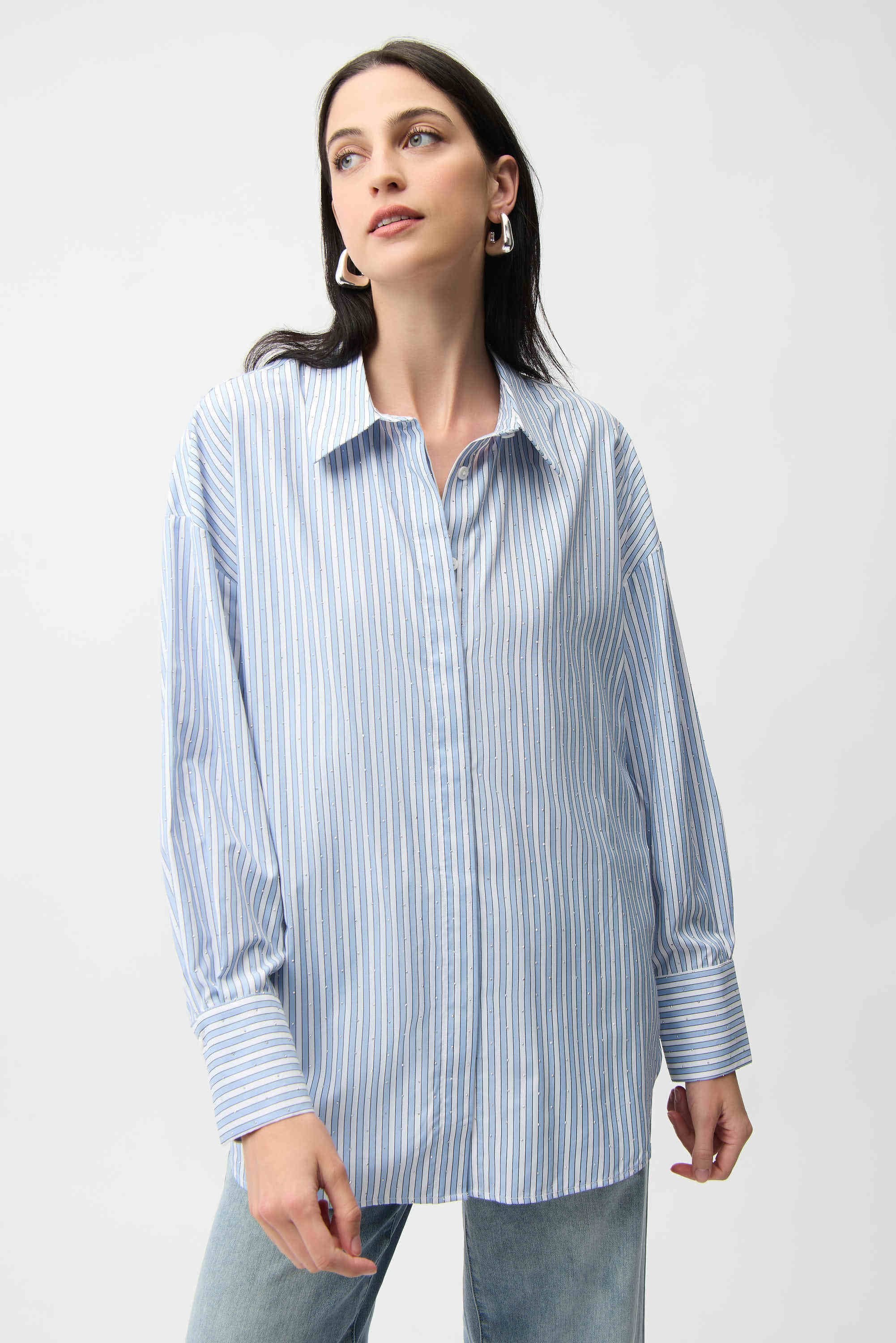 Woman wearing a light blue striped shirt against a white background