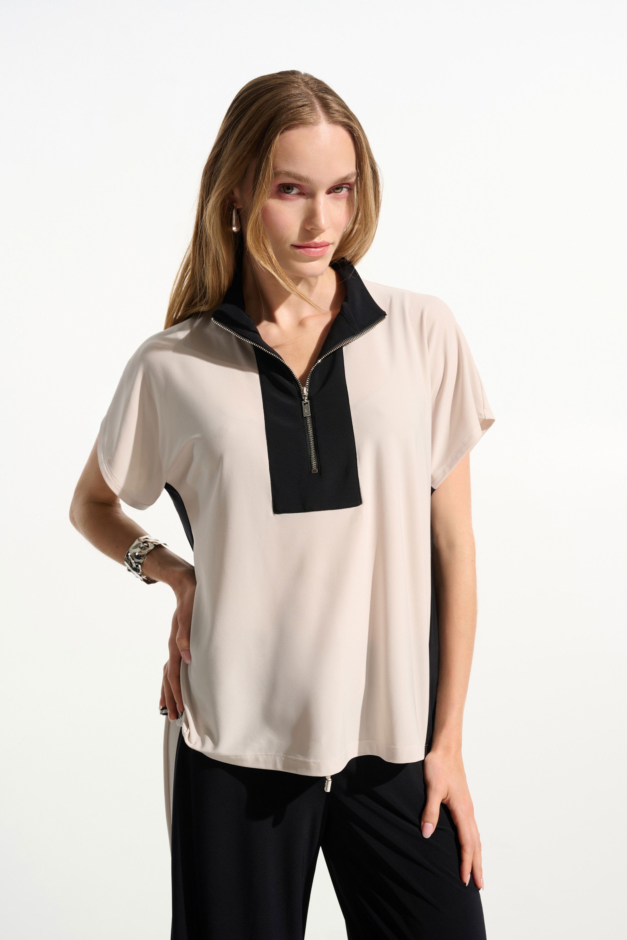 Woman wearing a two-tone blouse with black and beige colors on a white background