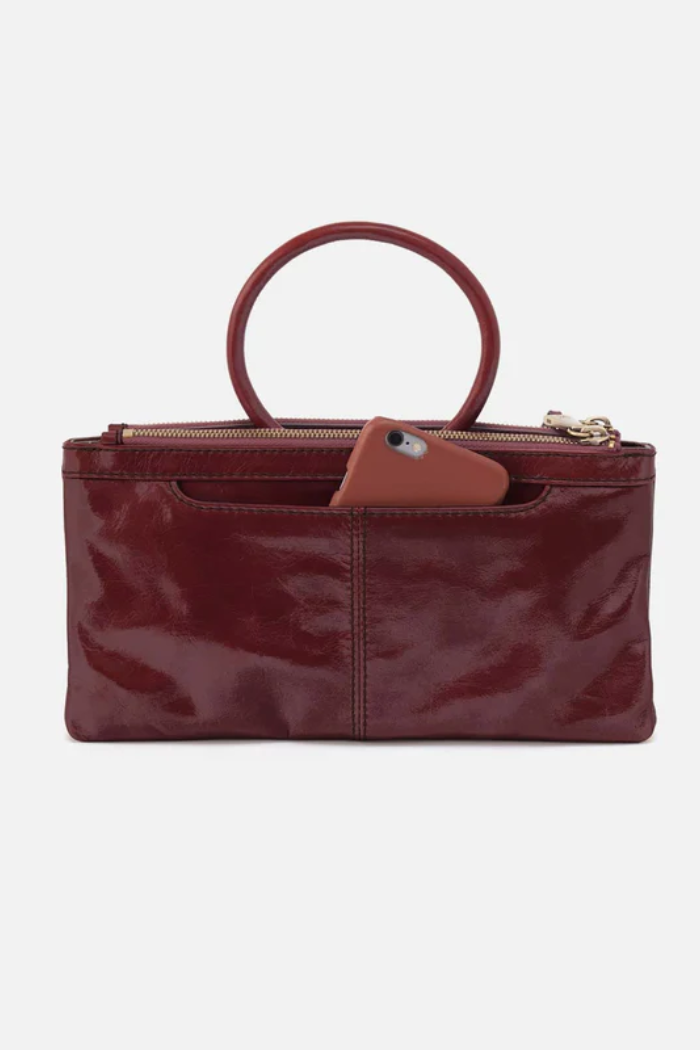 Red handbag with a brown handle on a white background