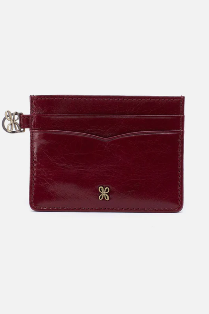 Red leather cardholder with a gold butterfly emblem on a white background