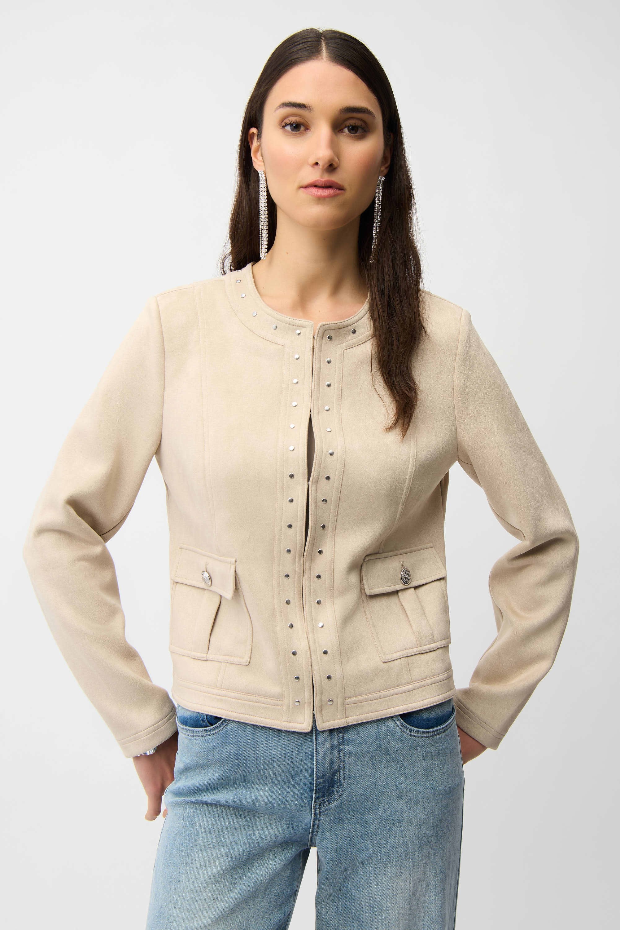 Woman wearing a beige jacket and blue jeans on a white background