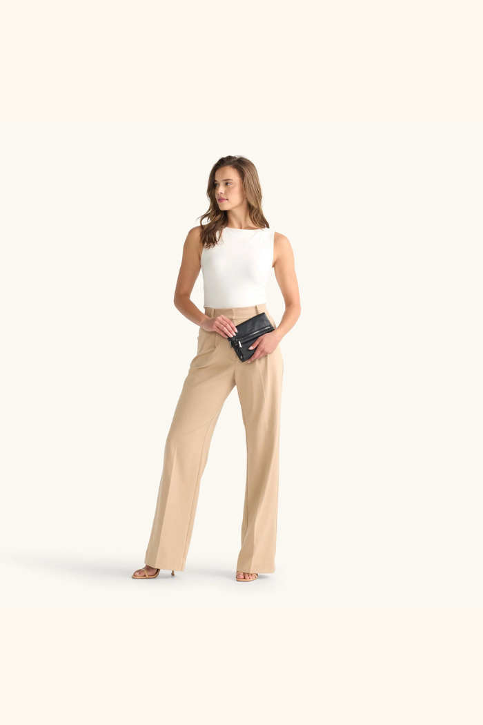 Woman wearing a white top and beige pants on a white background