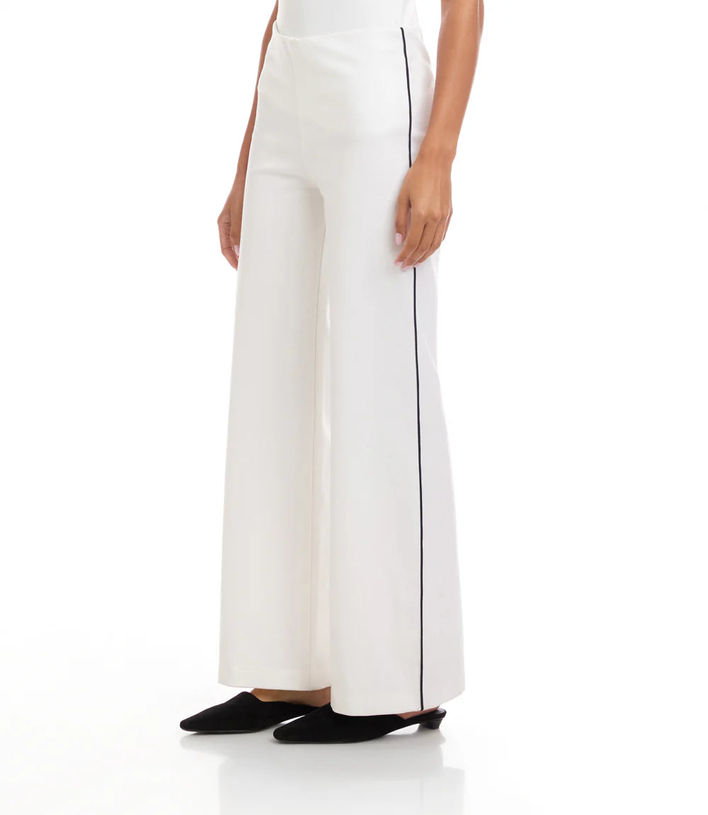 White pants with black piping worn by a person on a white background