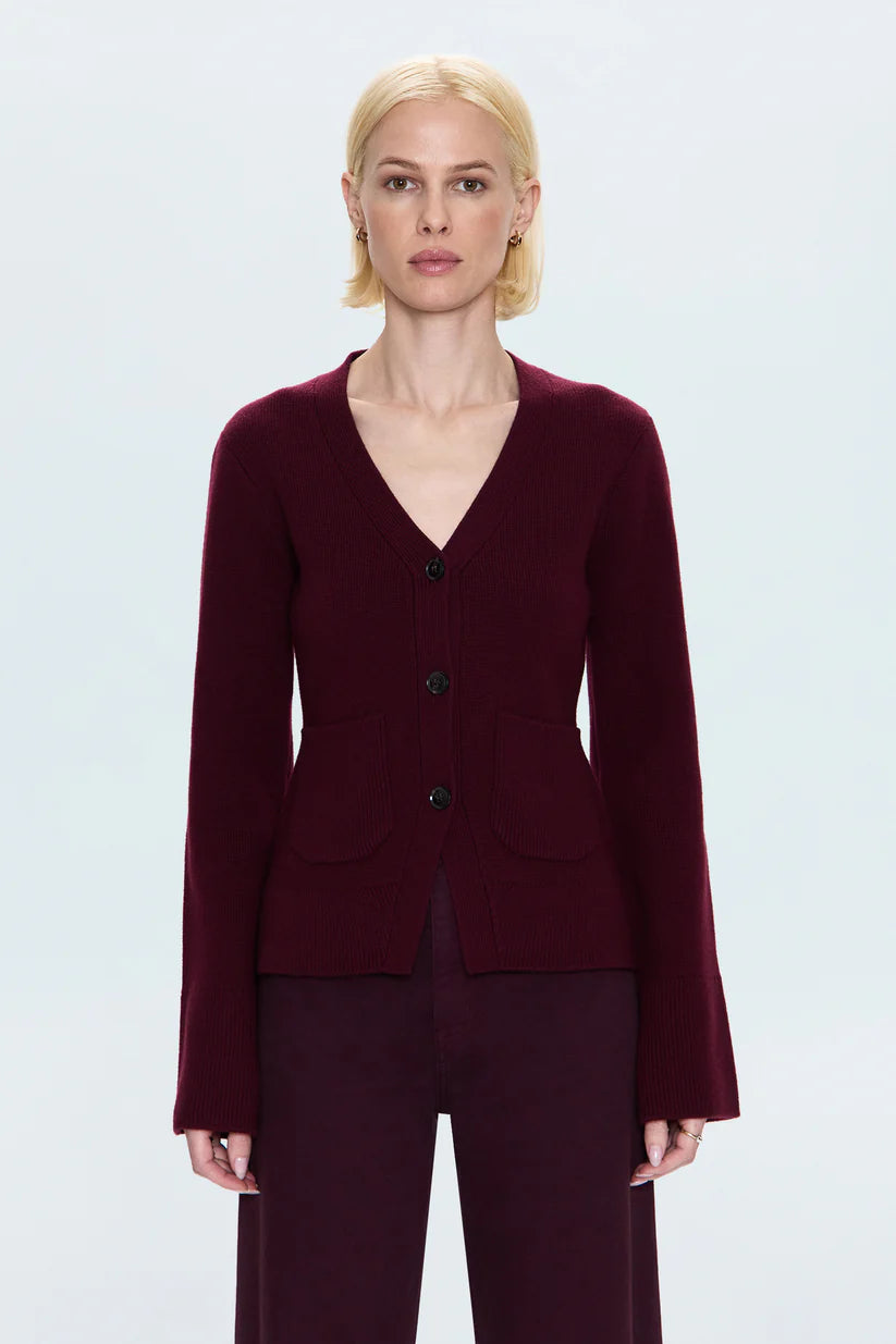Woman wearing a burgundy suit against a light gray background