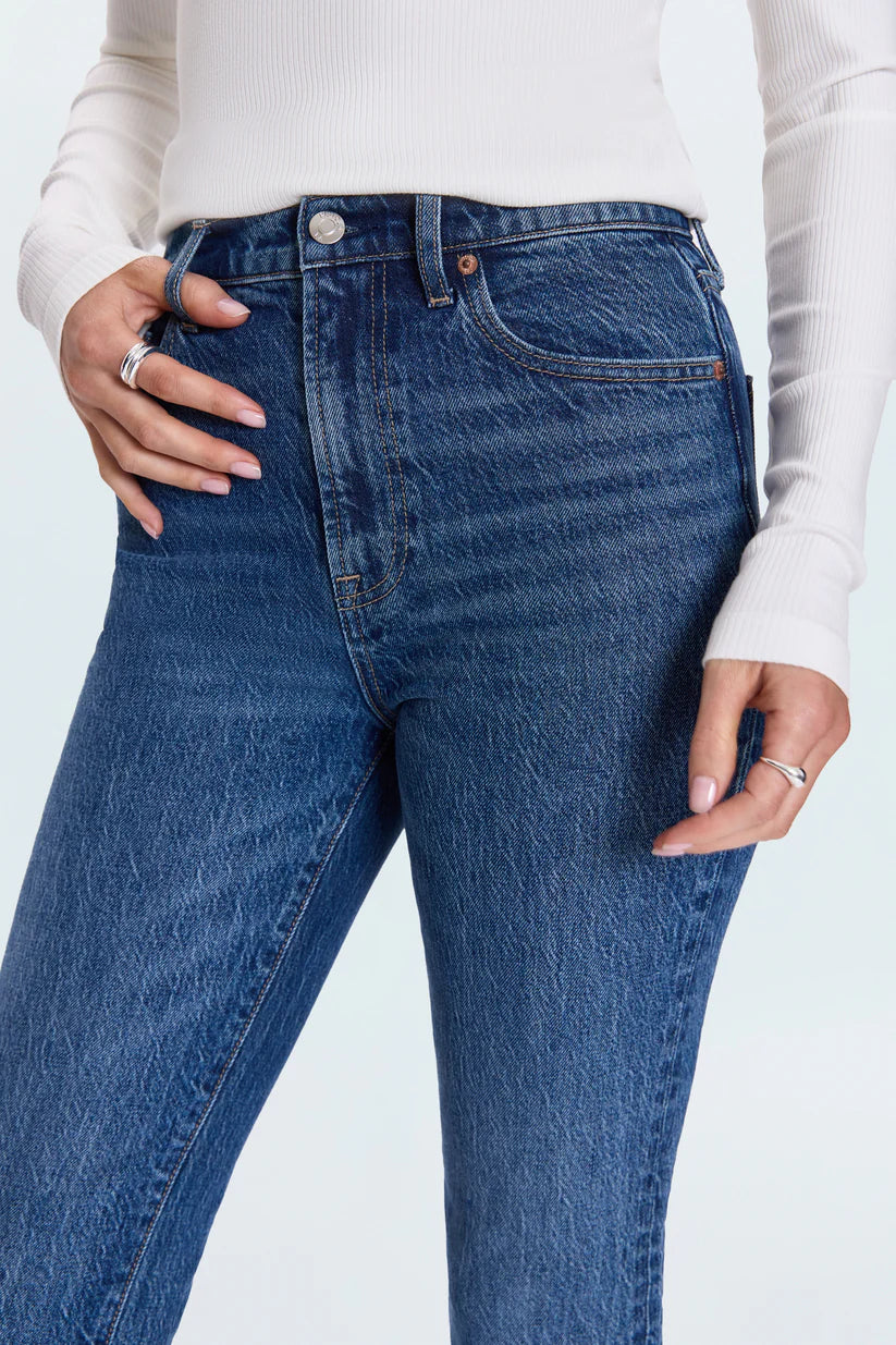 Person wearing blue jeans with a white background