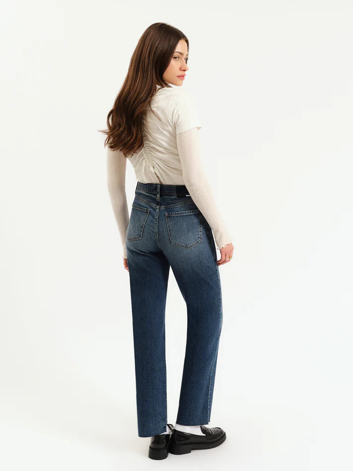 Woman wearing blue jeans and a white shirt on a white background
