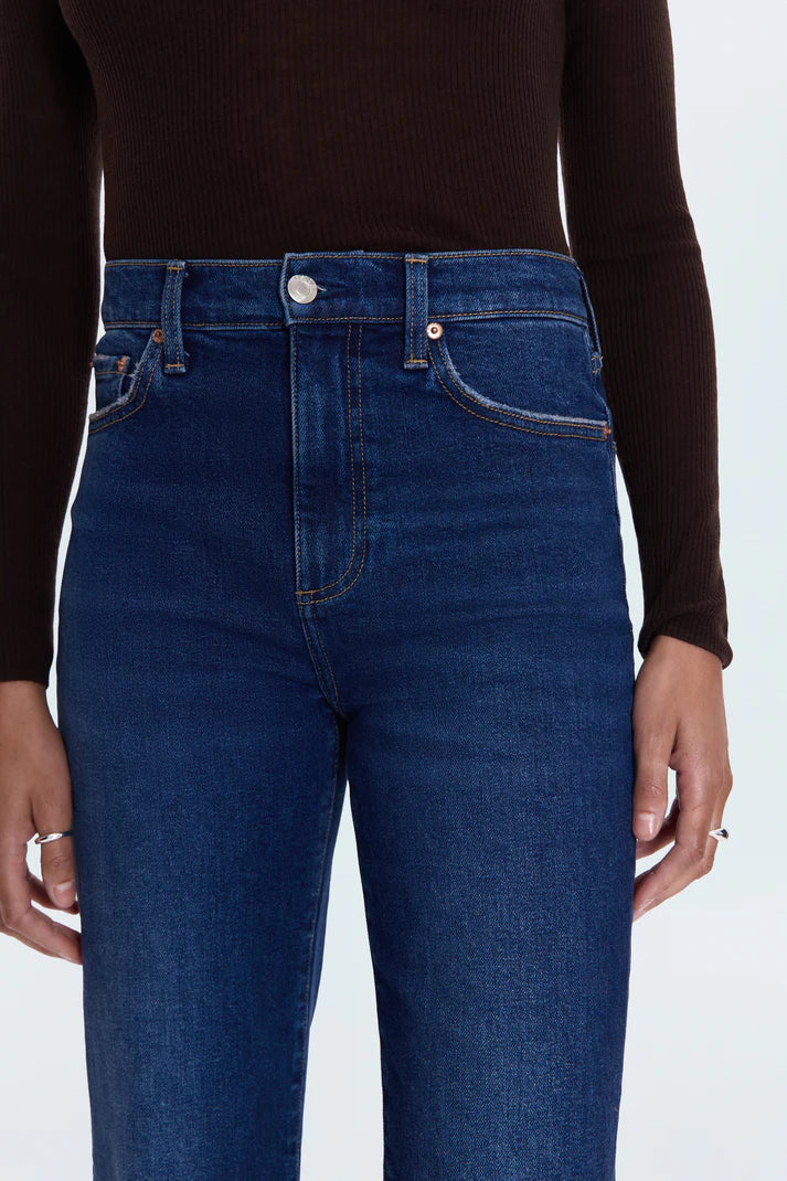 Person wearing dark blue jeans and a black long-sleeve shirt on a white background