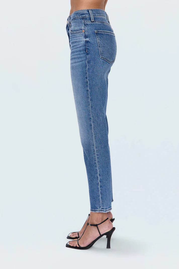 Blue jeans worn by a person on a white background