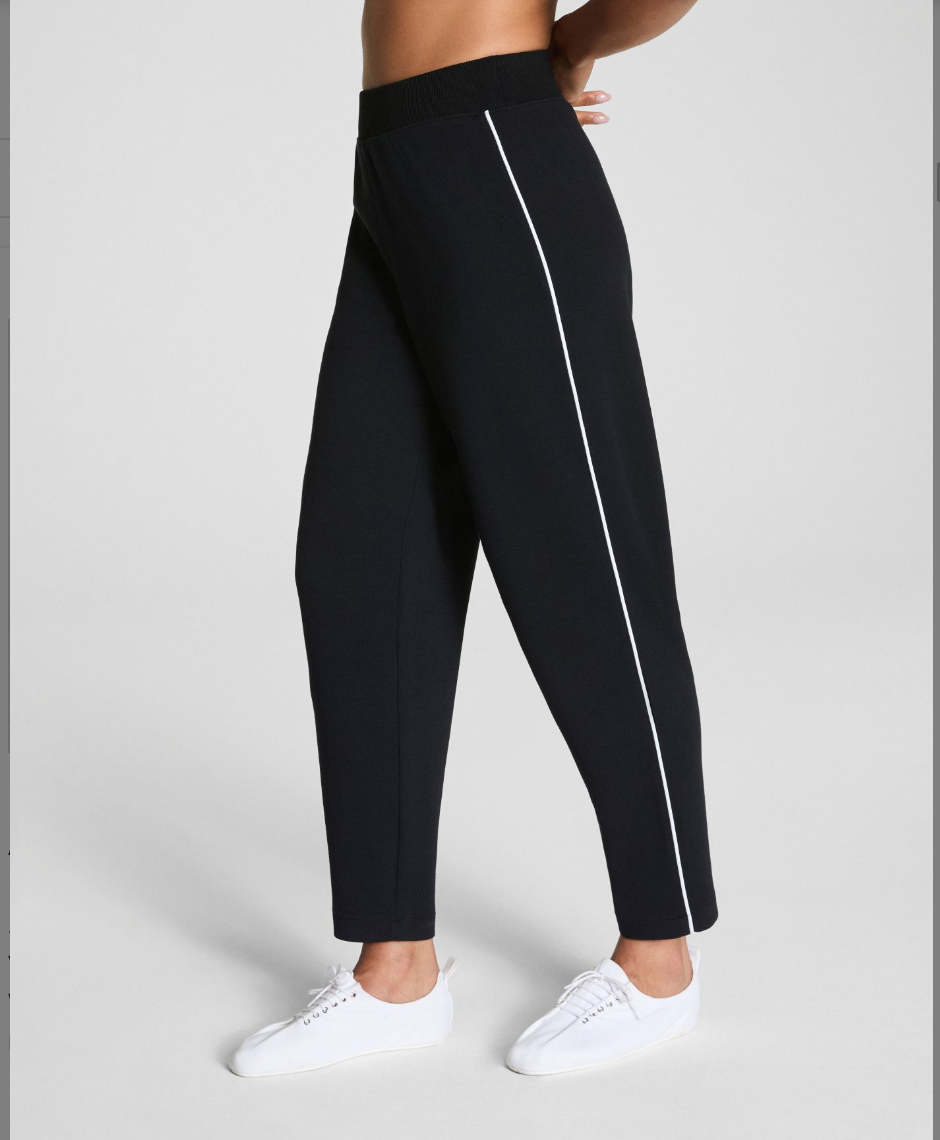 Black jogger pants with a white stripe on a gray background