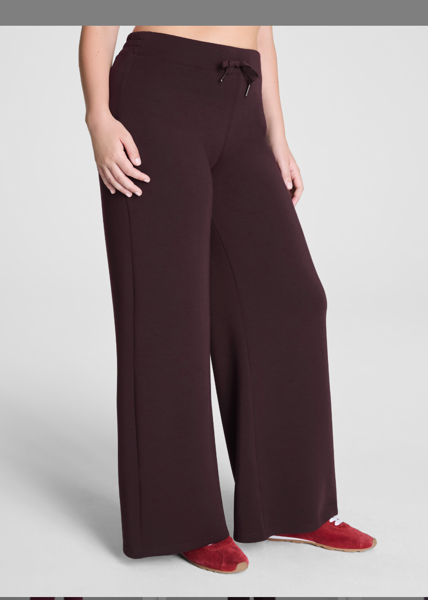 Dark brown wide-leg pants worn by a person on a light gray background