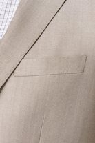 Close-up of a beige suit jacket with a pocket detail.