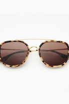 Sunglasses with tortoiseshell frame and brown lenses on a white background