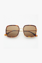 Sunglasses with tortoiseshell frame and brown lenses on a white background