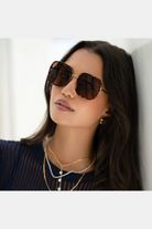 Woman wearing sunglasses with a neutral background