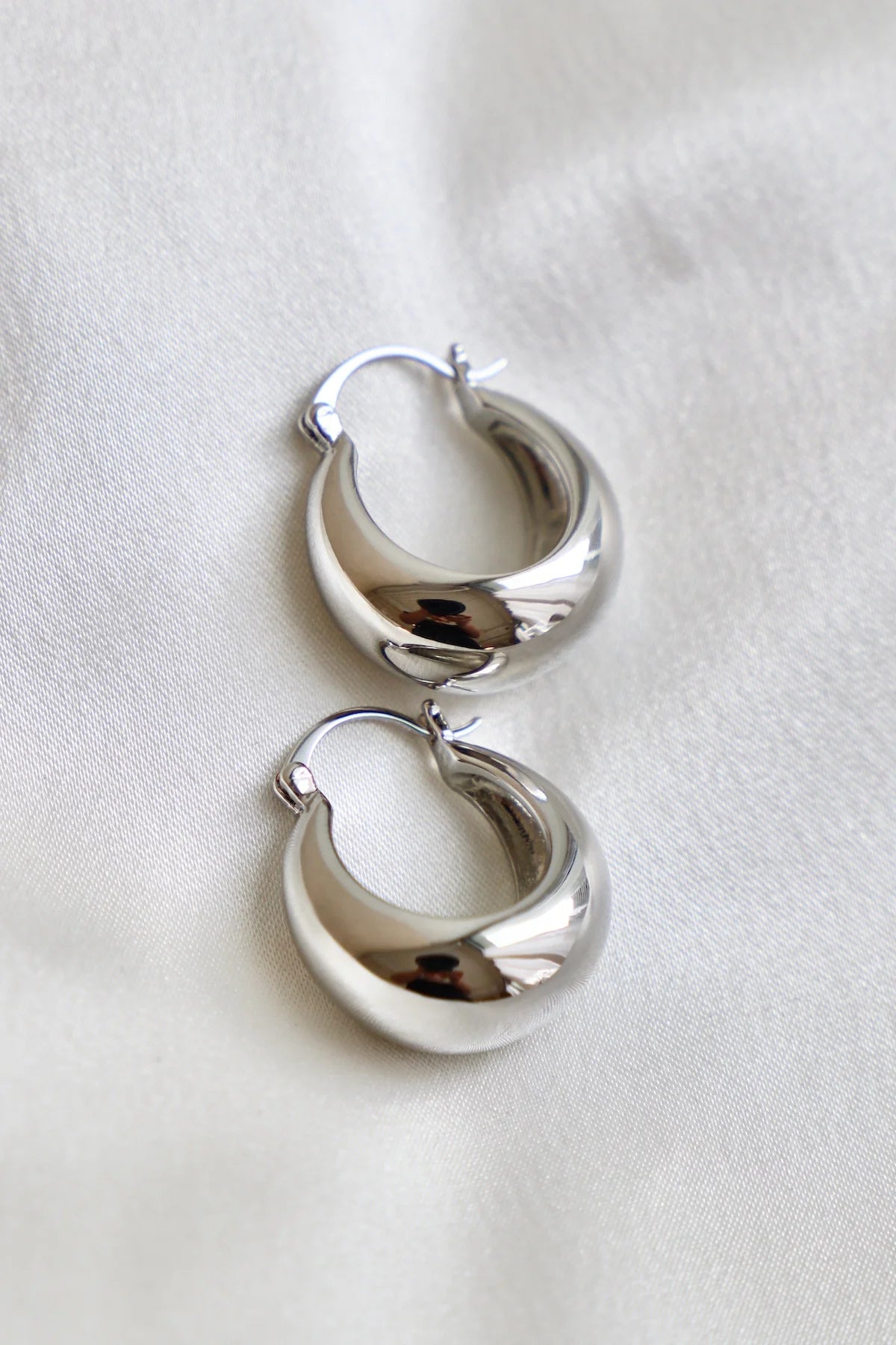 Pair of silver hoop earrings on a white background